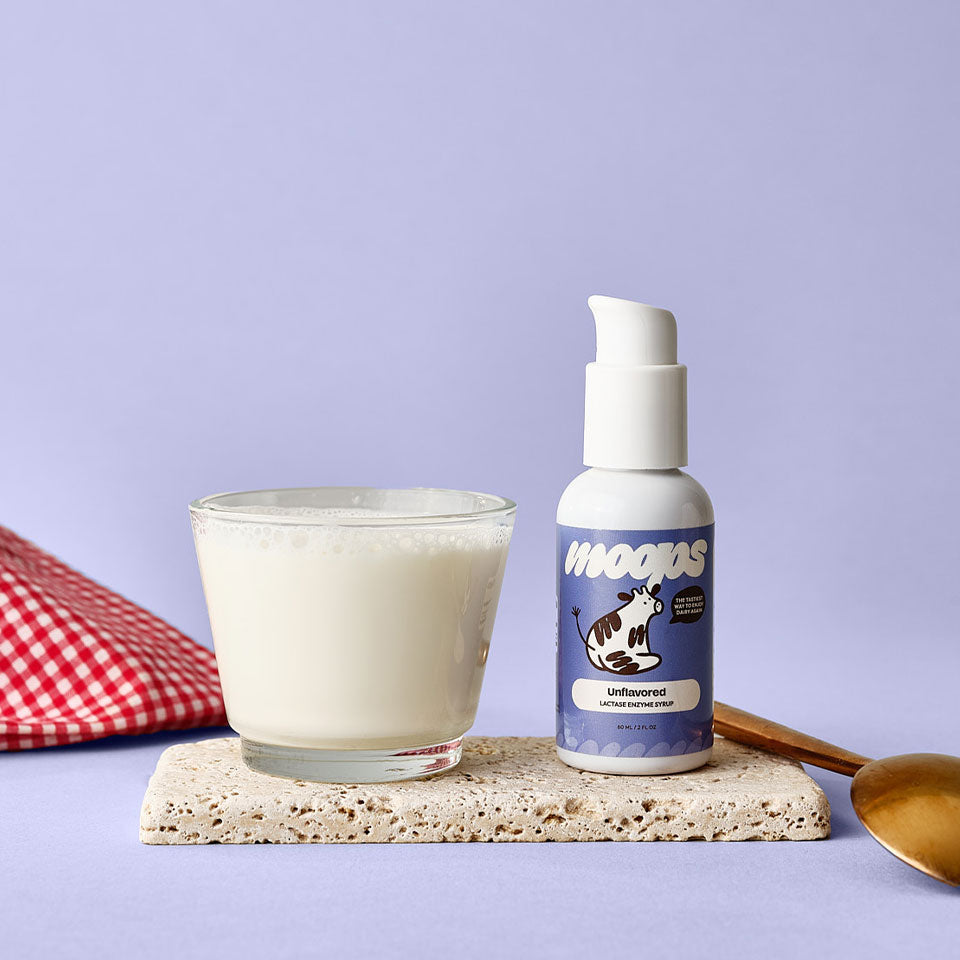 Unflavored Moops bottle next to a glass of milk, spoon, and napkin.