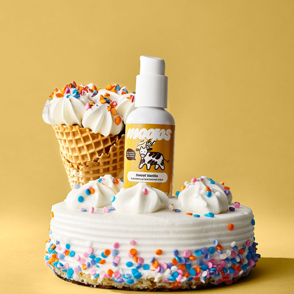 Sweet vanilla Moops bottle on top of a small vanilla cake and a vanilla ice cream waffle cone.